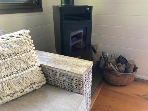a living room with a bench and a fireplace at Daintree Magic Holiday House in Cow Bay