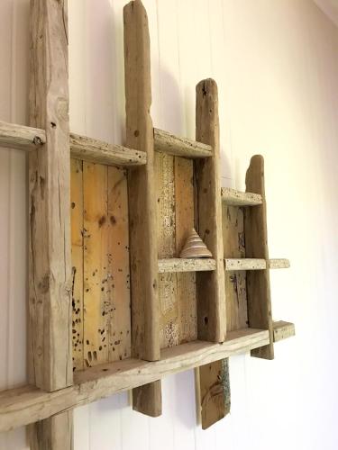a wooden shelf hanging on a wall at Daintree Magic Holiday House in Cow Bay
