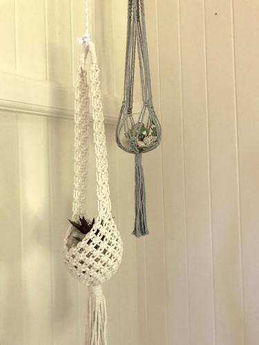 a white hanging basket with a plant in it at Daintree Magic Holiday House in Cow Bay