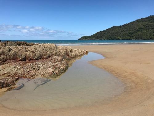 a beach with a pool of water in the sand at Daintree Magic Holiday House in Cow Bay