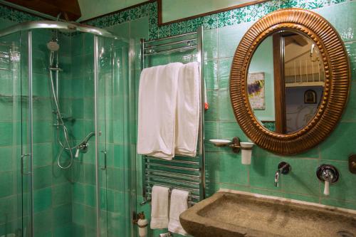 a green bathroom with a sink and a mirror at Villarose in Castelbuono