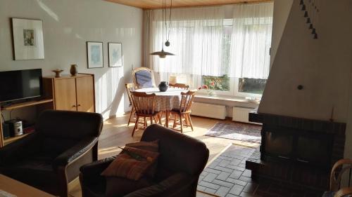 a living room with a table and chairs and a dining room at Haus Antje in Norddeich