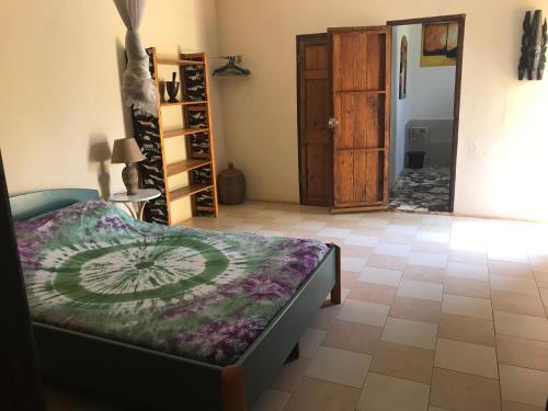 a room with a bed and a room with a door at The Gunjur Project Lodge in Gunjur