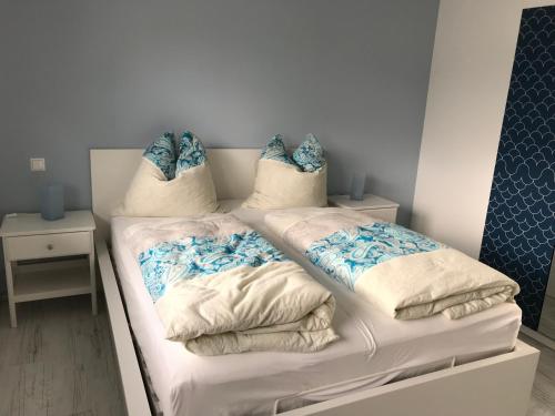 a bedroom with two beds with blue and white pillows at Haus Seewind Hohenfelden in Hohenfelden