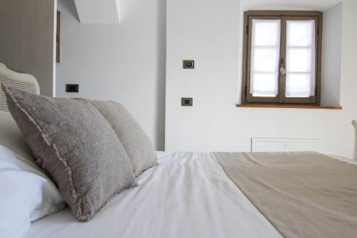 a bed with a pillow and a mirror on the wall at Agriturismo Treterre in Pianello Del Lario