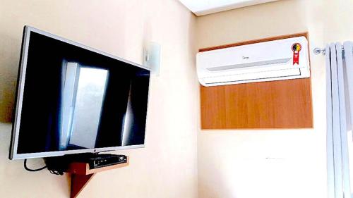 a flat screen tv hanging on a wall at Hotel Luxatel (Adults Only) in Sao Paulo