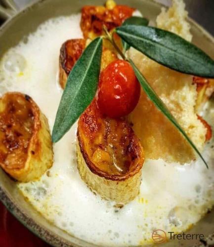 a plate of food with fruit and leaves on it at Agriturismo Treterre in Pianello Del Lario
