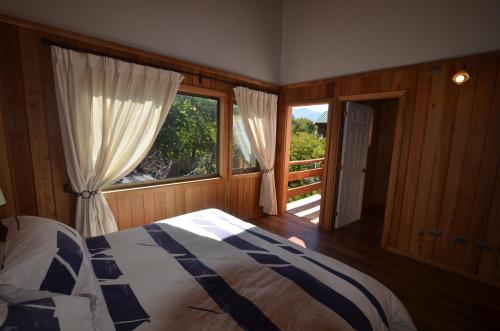una camera da letto con un letto e una grande finestra di Cabañas Las Cabras a Las Trancas