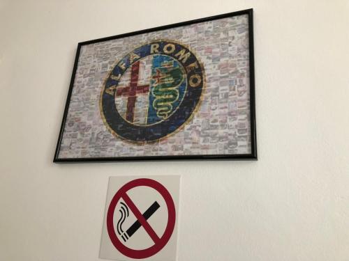 a picture hanging on a wall with a sign on it at Mosaico Alfetta Hostel in Timişoara
