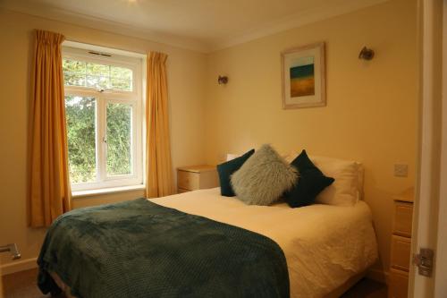 a bedroom with a bed with pillows and a window at Seashells in Newquay