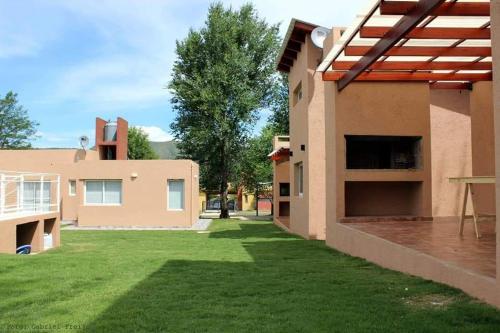un patio trasero de una casa con césped verde en Kawsay Complejo de Cabañas en San Antonio de Arredondo