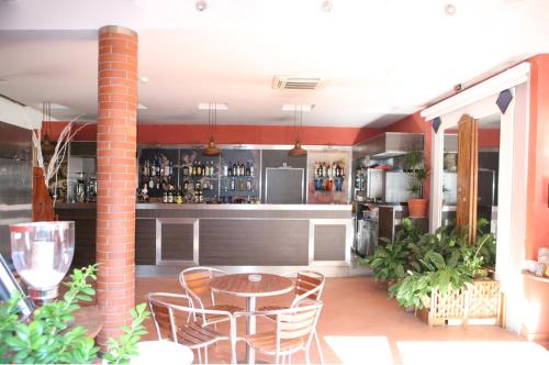 a patio with a table and chairs and a bar at Agorà Hostel in Pompei