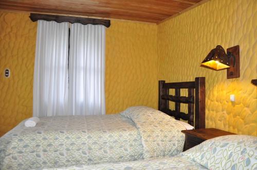a bedroom with a bed and a window and a bed sidx sidx sidx at Hotel Museo la Posada del Molino in El Cocuy