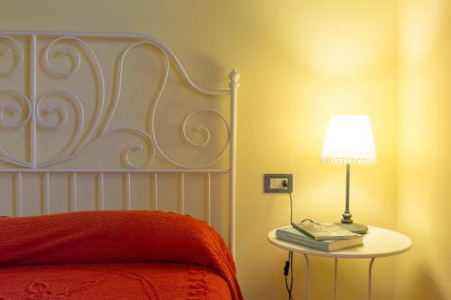 a bedroom with a bed with a table with a lamp at Omas Haus in Toscolano Maderno