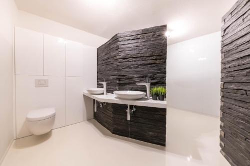 a bathroom with two sinks and a stone wall at Halna Residence in Krynica Zdrój