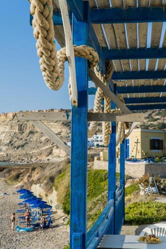 a blue structure with a rope on a beach at Zorbas Studios in Lefkos Karpathou