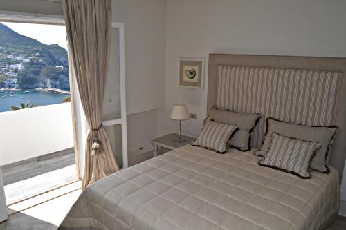 a bedroom with a large bed with a large window at Maridea Casa Vacanza- Le Alcove sul Mare Suites in Ponza