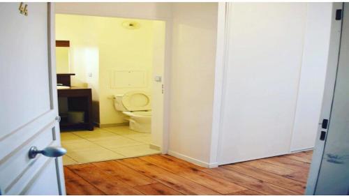 une porte ouverte menant à une salle de bains pourvue de toilettes. dans l'établissement Studio à 1 kilomètre de Disneyland Paris, à Montévrain