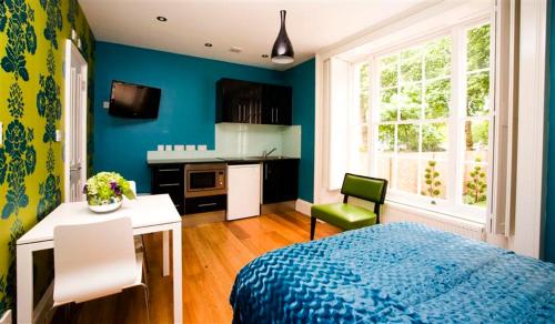 um quarto azul com uma cama e uma cozinha em Paddington Green Serviced Apartments by Concept Apartments em Londres