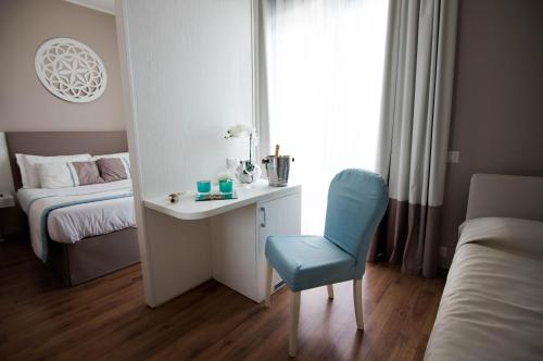 a bedroom with a desk and a bed and a blue chair at Hotel Mediterraneo in Lido di Latina 