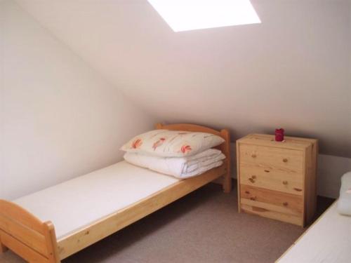 a small bedroom with a bed and a night stand at Magdolna Ház in Szögliget