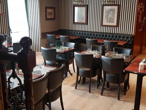 a restaurant with tables and chairs in a room at Hôtel Jeanne D'Arc in Saint-Chély-dʼApcher
