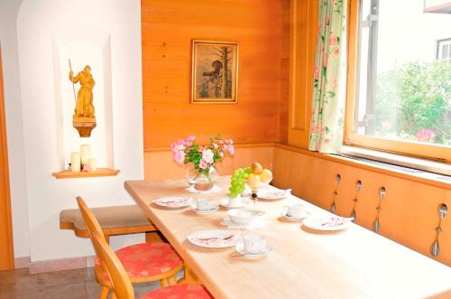 a dining room with a wooden table with flowers on it at Ahorn Chalet in Mayrhofen