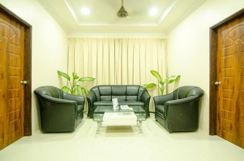 a living room with two leather chairs and a coffee table at Hulhan'gu Lodge in Himmafushi