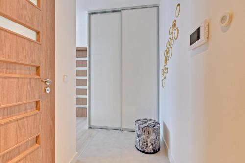 a glass door leading into a hallway with a suitcase at INA Rent - Tre Mare Apartamenty in Gdańsk
