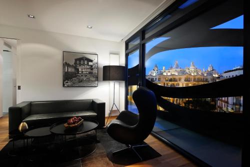 a living room filled with furniture and a large window at Suites Avenue in Barcelona