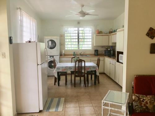 a kitchen with a table and a white refrigerator at Tranquility by the Sea in Vieques
