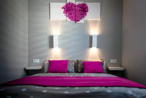 a bedroom with a large bed with pink pillows at APARTAMENT ELEGANCE PINK in Rewal
