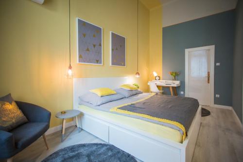 ブダペストにあるPosh Loft in the Centreのベッドルーム(大型ベッド1台、青い椅子付)