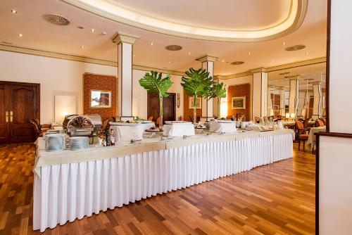un salon avec un long comptoir et des tables blanches dans l'établissement Hotel Roger de Llúria, à Barcelone
