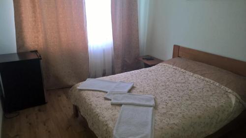a bedroom with a bed with two towels on it at Dnister Hotel Complex in Zhvanets