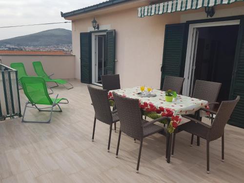 eine Terrasse mit einem Tisch und Stühlen auf dem Balkon in der Unterkunft Apartments Ivona in Trogir