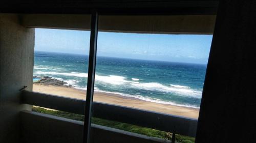 a view of the ocean from a window at Stella Maris in Amanzimtoti