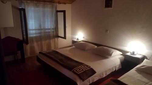 a bedroom with a bed with two lamps on it at Begovi Dvori in Rab
