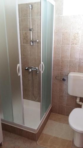 a shower with a glass door in a bathroom at Begovi Dvori in Rab