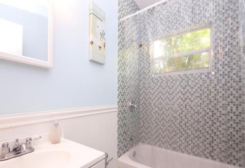 a bathroom with a sink and a tub and a window at Bikini Lodge in Miami Beach