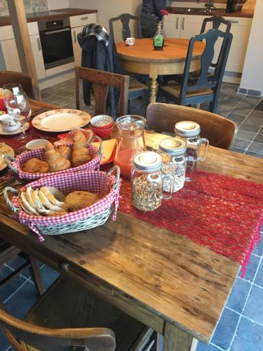 a wooden table with baskets of food on it at B&B De Hostelier in Ursel