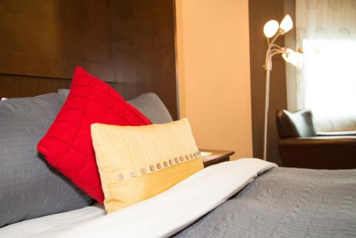 a red pillow sitting on top of a bed at Days Inn by Wyndham Berthierville in Berthierville