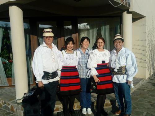 un grupo de personas de pie en frente de un edificio en Pensiunea Mara, en Deseşti