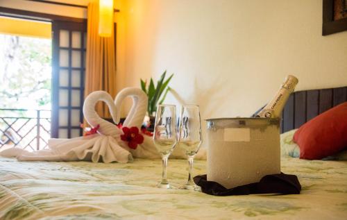 a table with two wine glasses and a champagne bottle at Hotel Aconchego Porto de Galinhas in Porto De Galinhas