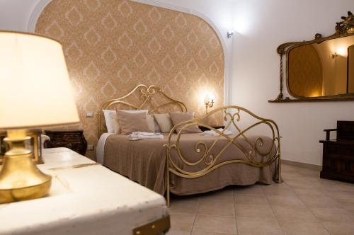 ナポリにあるdomus sanfeliceのベッドと鏡が備わるホテルルーム