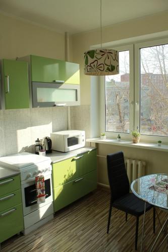 a kitchen with green cabinets and a table at Happy Day in Narva