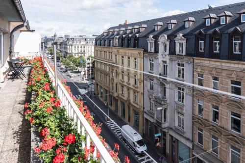 a view of a city street with flowers on a balcony at The Queen Luxury Apartments - Villa Carlotta in Luxembourg