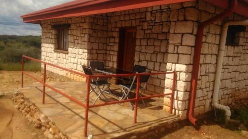 a small brick house with a table and chairs outside at Murangi Travel Lodge in Windhoek