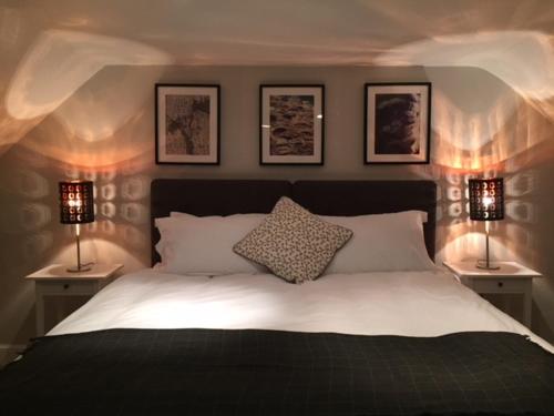 a bedroom with a bed with three pictures on the wall at Leirsinn Mhor in Killin