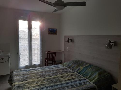 a bedroom with a bed and a ceiling fan at Auberge du Bon Vivant in Argelès-sur-Mer